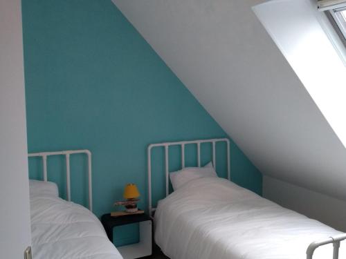 - 2 lits dans une chambre avec un mur bleu dans l'établissement Maison Le Palais, 4 pièces, 5 personnes - FR-1-418-182, au Palais