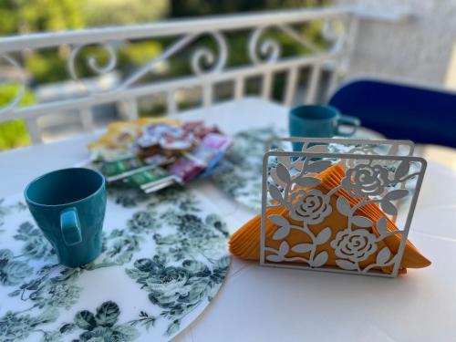 una mesa con dos tazas y un plato de comida en VILLA GIORGIA, en Savelletri di Fasano