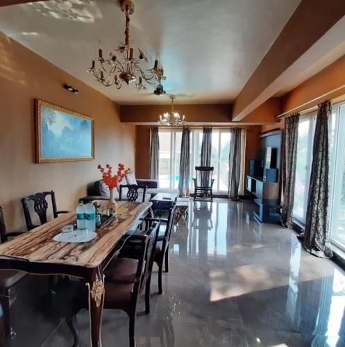 a dining room with a wooden table and chairs at West Vally Villa - Casa West in Panchgani