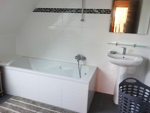 une salle de bain blanche avec une baignoire et un lavabo dans l'établissement Maison familiale - 8 pers - Proche mer et port - Jardin et terrasse - FR-1-639-40, à Sarzeau