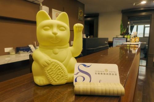 a yellow toy cat sitting on a counter next to a box at SongHo Hotel in Magong