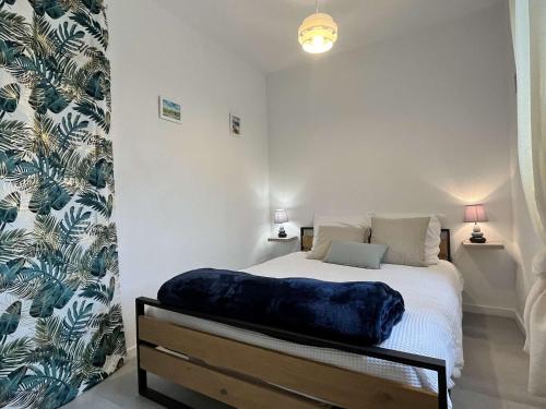 Appartement Noirmoutier-en-l'Île, 2 pièces, 4 personnes - FR-1-224B-150 في نوارموتيير أون ليل: غرفة نوم مع سرير مع لاب توب عليه