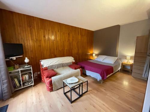 une chambre d'hôtel avec un lit et un canapé dans l'établissement Studio Cosy 1* avec Balcon, au Centre de Brides-les-Bains, 2 Pers, Proche Thermes et Télécabine - FR-1-512-253, à Brides-les-Bains