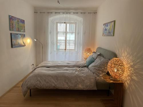 a bedroom with a bed with two lamps and a window at Altstadt Bed&Bike in Gmunden