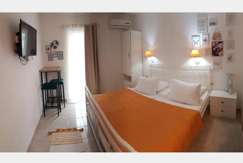 - une chambre avec un grand lit et une couverture orange dans l'établissement Apartment Luna, à Drvenik
