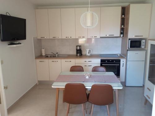 cocina con mesa y sillas y TV en Apartments Smiljana Mucić, en Makarska