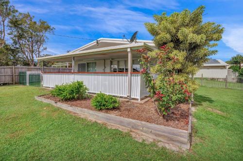 a house with a tree in a yard at 13 Indigo Avenue - 'Indigo Sands' - Rainbow Beach in Rainbow Beach