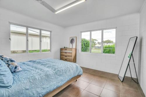 a bedroom with a bed and two windows at 13 Indigo Avenue - 'Indigo Sands' - Rainbow Beach in Rainbow Beach