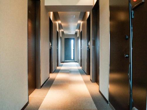 a hallway of a building with a long corridor at HOTEL LiVEMAX Saitama-Asaka-Ekimae in Asaka