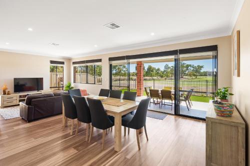 a living room with a table and chairs and a couch at The Links - fairway views, walk to town, air-con in Dunsborough
