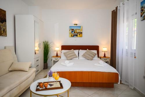 a small bedroom with a bed and a couch at Beach House Poseydon in Mlini