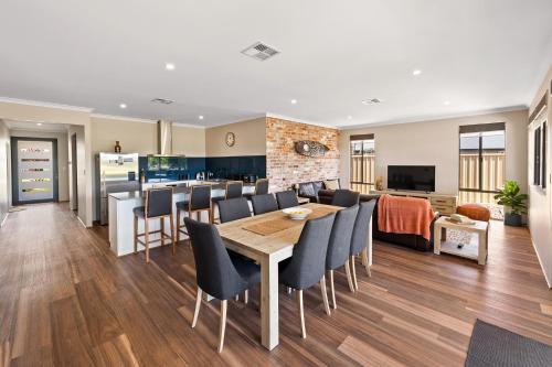 a dining room and living room with a table and chairs at The Links - fairway views, walk to town, air-con in Dunsborough