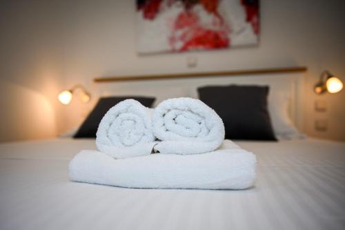 a stack of towels sitting on a bed at Beach House Poseydon in Mlini