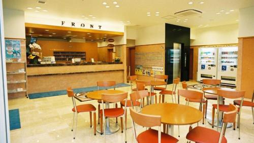 un ristorante con tavoli, sedie e bancone di Toyoko Inn Musashi-nakahara Ekimae a Kawasaki