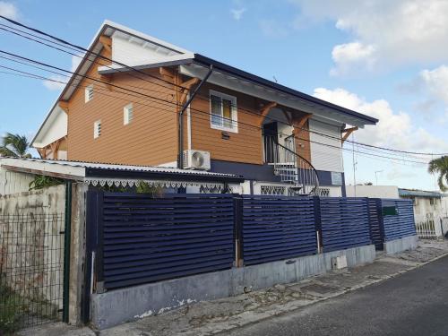 a house with a fence in front of it at L'améthyste in Saint-François