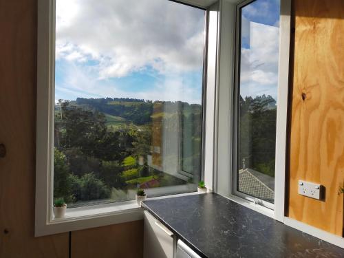 a kitchen with a large window with a view at Relax in Kenmure in Dunedin
