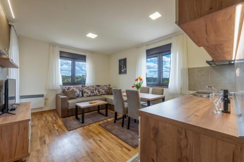 a kitchen and living room with a couch and a table at Monix Palace Zlatibor in Zlatibor