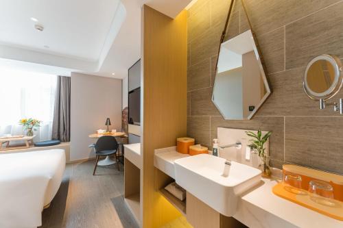 a bathroom with two sinks and a mirror at Atour Hotel Tongxiang Wuzhen in Tongxiang