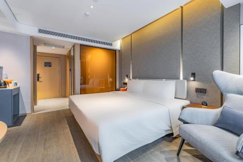 a bedroom with a large white bed and a couch at Atour Hotel Xian Hujia Temple in Xi'an
