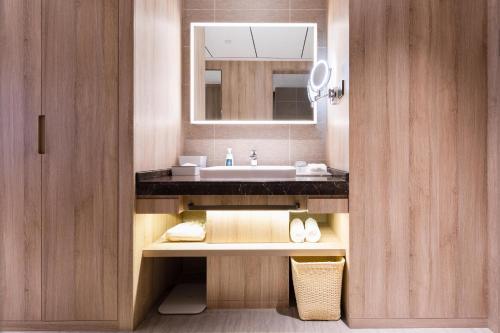 La salle de bains est pourvue d'un lavabo et d'un miroir. dans l'établissement Atour Hotel Nanning North Lake Railway Station, à Nanning