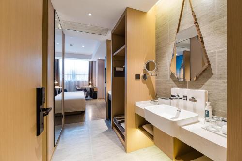 a bathroom with a sink and a mirror at Atour Hotel Nanjing Olympic Sports Center Tianhe Plaza in Nanjing