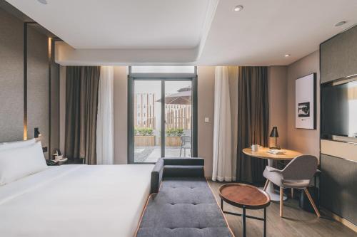 Habitación de hotel con cama y mesa en Atour Hotel Ningbo Jishi Harbor Outlets, en Ningbo