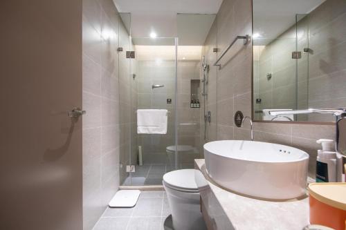 a bathroom with a sink and a toilet and a shower at Atour Hotel X Nanshan Coastal City Shenzhen in Shenzhen