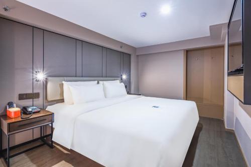 Ένα ή περισσότερα κρεβάτια σε δωμάτιο στο Atour Hotel Qingdao CBD Hangzhou Road