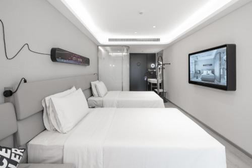 Cette chambre comprend 2 lits et une télévision à écran plat. dans l'établissement Atour Light Hotel Nanjing Agricultural University, à Nankin