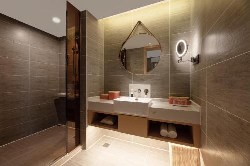 a bathroom with a sink and a mirror at Atour Hotel Xian Chanba International Convention Exhibition Center in Xi'an