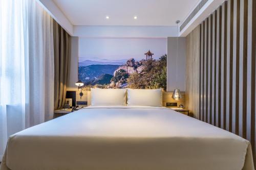 Säng eller sängar i ett rum på Atour Hotel Weifang Railway Station Youth Road