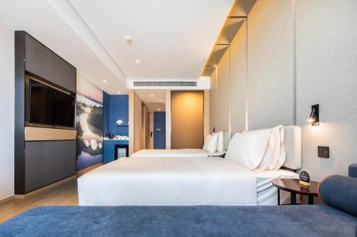 A bed or beds in a room at Atour Hotel Nanchang Red Valley Beach Causeway Bay