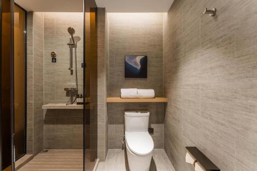 a bathroom with a toilet and a shower at Atour Hotel Nanchang Red Valley Beach Qiushui Plaza in Nanchang
