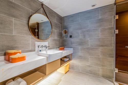 a bathroom with a sink and a mirror at Atour Hotel Xian Hujia Temple in Xi'an