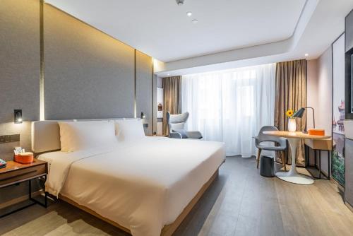 a hotel room with a large bed and a desk at Atour Hotel Xian Hujia Temple in Xi'an