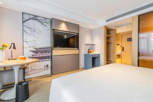 a hotel room with a large bed and a tv at Atour Hotel Xian Hujia Temple in Xi'an