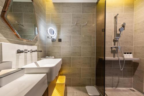 a bathroom with a sink and a shower at Atour Hotel Nanchang Red Valley Beach Causeway Bay in Nanchang