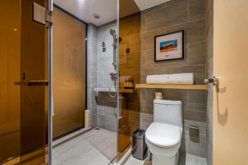 a bathroom with a toilet and a glass shower at Atour Hotel Xian Hujia Temple in Xi'an