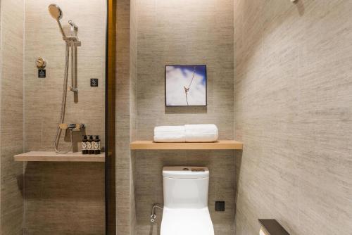 a bathroom with a toilet and a shower at Atour Hotel Nanchang Red Valley Beach Qiushui Plaza in Nanchang