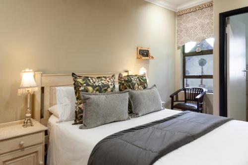 um quarto com uma cama, uma cadeira e uma janela em InnJoy Boutique Hotel em Centurion