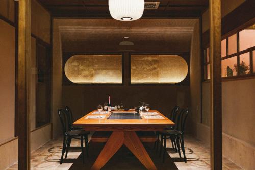 a dining room with a wooden table and chairs at Kominkayado LOOF Sakanoie in Fuefuki