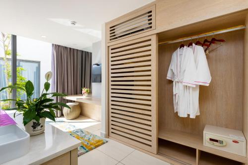 a bathroom with a closet with white clothes at Okinawa Villas and Beach Club - Oceanami Resort in Long Hai