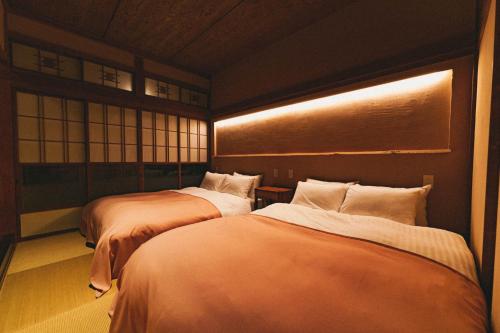 מיטה או מיטות בחדר ב-古民家宿るうふ 坂之家