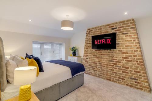 a bedroom with a brick wall and a bed at Luxury 6 bed with parking near broads in Clippesby