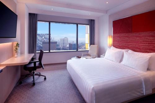 Ένα ή περισσότερα κρεβάτια σε δωμάτιο στο Grand Mercure Jakarta Harmoni