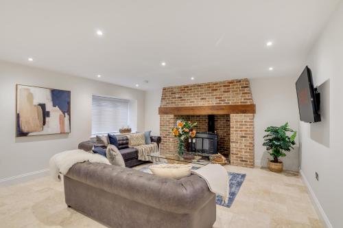 a living room with a couch and a fireplace at Spacious 6-Bed Home, Near The Norfolk Broads in Clippesby