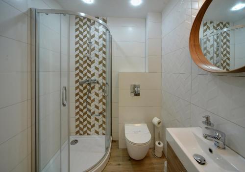 uma casa de banho com um chuveiro, um WC e um lavatório. em Apartament Sun & Ski Weekend Willa Nad Łomnicą 15 - centrum 100m em Karpacz