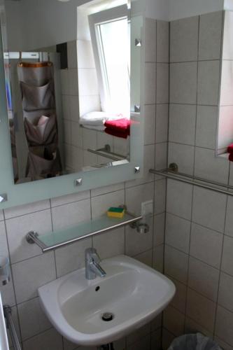 a white bathroom with a sink and a mirror at Appartement Eveline in Velden am Wörthersee
