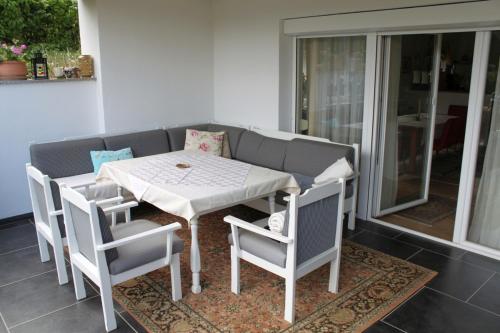 einen weißen Tisch und Stühle auf einer Terrasse in der Unterkunft Appartement Eveline in Velden am Wörthersee