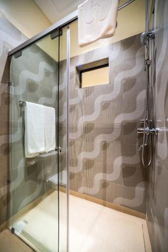a shower stall in a bathroom with a camouflage wall at Verona Hotel and Conference Center in Ruiru
